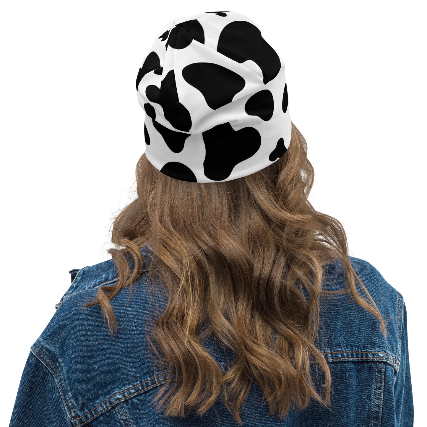 Model wearing unisex cow print beanie hat in black and white, soft double-layer knit, back view