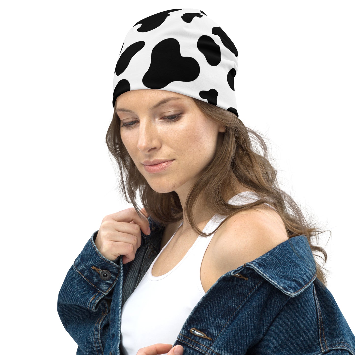 Model wearing unisex cow print beanie hat in black and white, soft double-layer knit, left side view