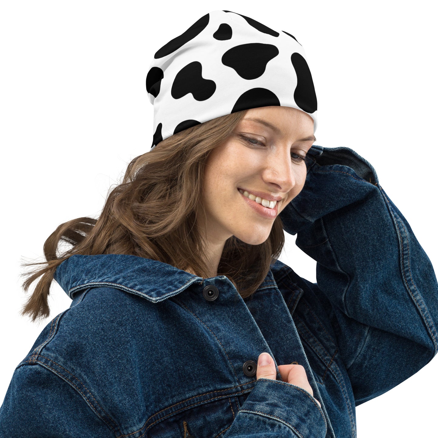 Model wearing unisex cow print beanie hat in black and white, soft double-layer knit, right side view
