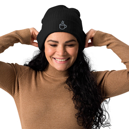 Model wearing ribbed knit beanie hat in black with embroidered coffee cup design, front view