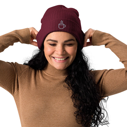 Model wearing ribbed knit beanie hat in burgundy with embroidered coffee cup design, front view