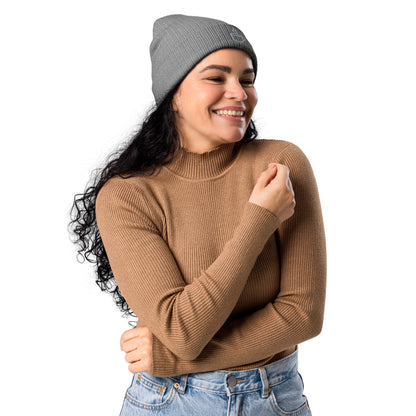 Model wearing ribbed knit beanie hat in light grey with embroidered coffee cup design, side view