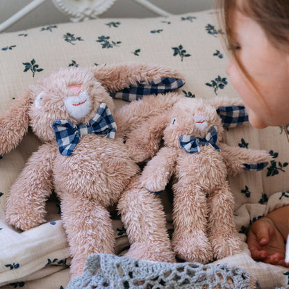 Group of small plush rabbits with blue gingham bows on nursery bedding – Mamutino